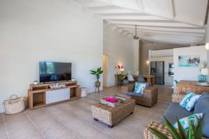 a living room with a couch and a tv and chairs at Villa Caiquetio in Jan Thiel