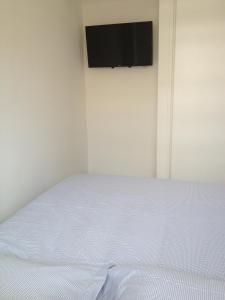 1 dormitorio con 1 cama y TV en la pared en Flore en Juan-les-Pins