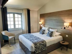 a hotel room with a bed and a chair at Abbaye des Capucins Spa & Resort in Montauban +70 photos