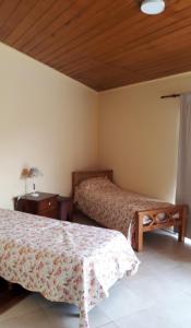1 dormitorio con 2 camas y techo de madera en Casa en Villa Allende Lomas en Villa Allende