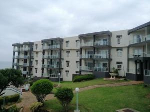 a large apartment building with a lawn in front of it at Seagull 509 in Margate