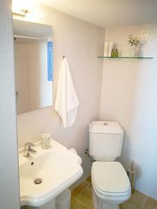 uma casa de banho com um WC branco e um lavatório. em Olive Bay Hilltop Apartments Ammouliani em Ammouliani