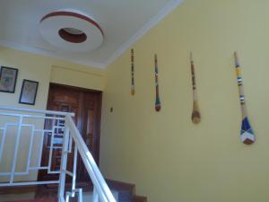 un couloir avec des battes de baseball suspendues sur un mur dans l'établissement The Clarice House, à Kisumu