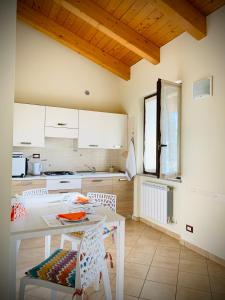 a kitchen with white cabinets and a table and chairs at Agriturismo Cascina Mariale in Albiano dʼIvrea
