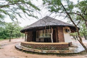 a small brick building with a thatched roof at ATKV Eiland Spa in Letsitele