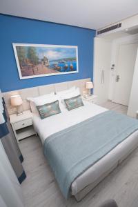 1 dormitorio con 1 cama grande y paredes azules en Ravvda Hotel en Estambul