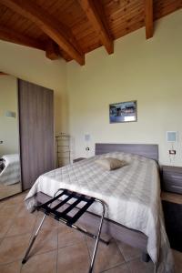1 dormitorio con 1 cama grande y techo de madera en Agriturismo Cascina Mariale, en Albiano dʼIvrea