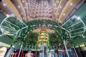 un centre commercial avec un grand plafond orné de plantes dans l'établissement Dusit Thani Dubai, à Dubaï