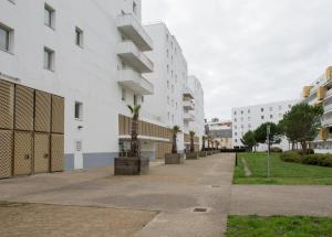 une rue vide dans une ville avec des bâtiments blancs dans l'établissement LE VOYAGEUR - Appartement avec vue mer, à Saint-Nazaire