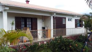 Una pequeña casa blanca con balcón. en Oiseaux du Paradis, en Le Tampon