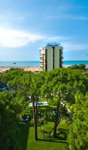 a hotel on the beach with trees in front of it at Hotel Italy in Bibione