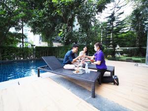 a group of people sitting on a bench with a baby at Fortune Courtyard Khao Yai Hotel Official in Mu Si