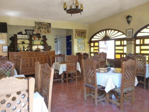 una sala da pranzo con tavoli, sedie e finestre di Hotel Posada Los Arcos a Città di Oaxaca