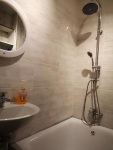 ein Bad mit einem Waschbecken, einer Dusche und einem Waschbecken in der Unterkunft NEXT TIME in Warschau