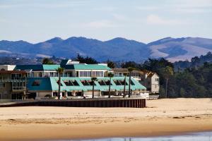 a resort on the beach with mountains in the background at SeaVenture Beach Hotel in Pismo Beach