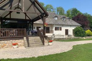 een huis met een groot terras en een veranda bij Le domaine du Lac in Villecerf