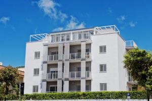 a white building with balconies and a blue sky at apARTments Sperlonga in Sperlonga