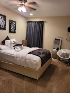 Beautiful 3 bed/2 Bath Cozy Get Away Home في لاس فيغاس: غرفة نوم بسرير ومروحة سقف