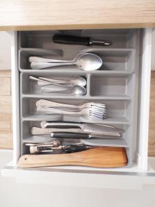 a drawer full of utensils in a cabinet at Old town center studio in Klaipėda