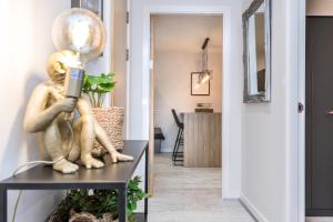 a hallway with a statue of a woman holding a cell phone at Host & Stay - Baltic Balcony Apt in Liverpool