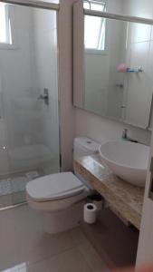 a bathroom with a toilet and a sink and a shower at Apto a uma quadra do mar em torres in Torres