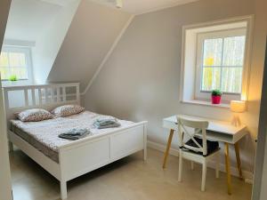 Schlafzimmer mit einem Bett, einem Schreibtisch und einem Fenster in der Unterkunft Przystań Piecek in Stręgielek