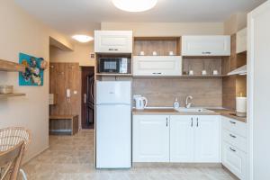 a kitchen with white cabinets and a white refrigerator at Aquamarine in Pomorie