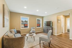 a living room with a couch and a tv at Liberty Bay Loft & Front Street Suite in Poulsbo