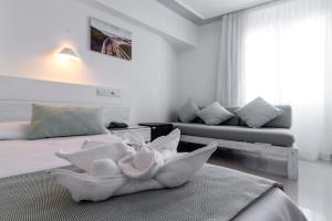 1 dormitorio con 2 camas y sofá en Hostal Bellavista Formentera, en La Savina