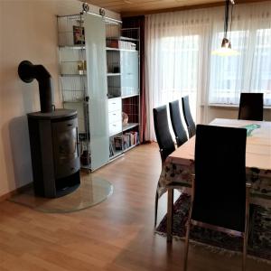 a living room with a table and a wood stove at Ferienhaus Hämmerle´s in Lustenau