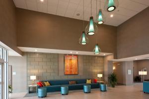 eine Lobby mit einem blauen Sofa und einem Gemälde an der Wand in der Unterkunft Holiday Inn Guin, an IHG Hotel in Yampertown