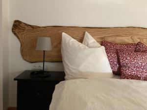 uma cama com almofadas e uma cabeceira de madeira em Gästehaus Lausnitz Ferienwohnung, Reda em Lausnitz
