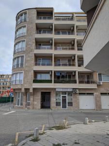 an apartment building with a parking lot in front of it at Aquamarine in Pomorie