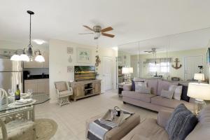 a large living room with a couch and a table at Peaceful condo with pool and brief walk to beach in Marco Island