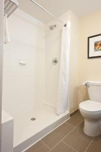 ein Bad mit einer Dusche und einem WC in der Unterkunft Holiday Inn Guin, an IHG Hotel in Yampertown