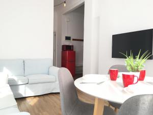 a living room with a white table and a white couch at Mar y Arena - 5 minutos a la playa y al centro in Santa Pola