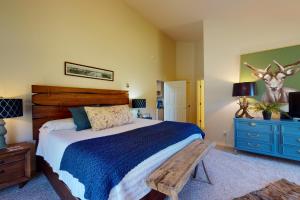 a bedroom with a bed with a wooden headboard and a table at Two Rivers Retreat in South Fork