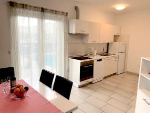 a kitchen with white appliances and a table with chairs at Villa Pineta in Fažana