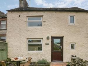 a brick house with a door and a table at The Snug in Matlock