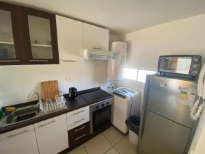eine kleine Küche mit Kühlschrank und Spüle in der Unterkunft Departamento en playa in La Serena