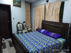 a bedroom with a bed with a blue comforter at Janjua lodges Murree in Murree
