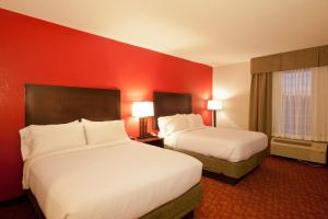 Holiday Inn Guin, an IHG Hotel في Yampertown: غرفة فندقية بسريرين وجدران حمراء