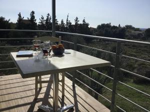 a table with two glasses of wine on a balcony at Blue Sky in Frangokastello
