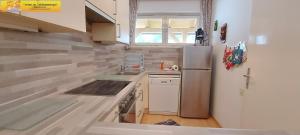 a small kitchen with a stainless steel refrigerator at Haus Enzian by FiS - Fun in Styria in Bad Mitterndorf