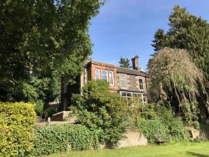 a large brick house with trees and bushes at Ivybank Lodge in Blairgowrie