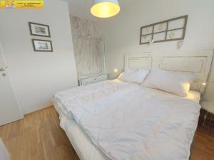 a bedroom with a large bed with white sheets at Apartment Grimminglounge by FiS - Fun in Styria in Bad Mitterndorf