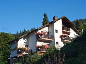 a white building with balconies and flowers on it at Gästehaus Heller in Elmstein