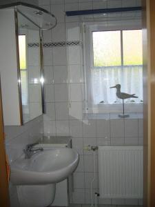 カロリーネンジールにあるMoin-Moinのバスルーム(洗面台付)、窓に鳥が1羽