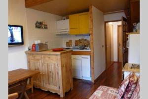 a small kitchen with a counter and a table at Le Rustica, 3 rooms, 3 stars, 6 people in Les Houches