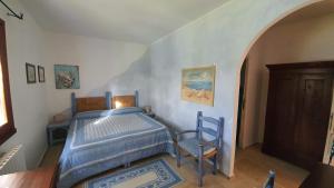 - une chambre avec un lit et une chaise dans l'établissement B&B La Murichessa, à Arzachena